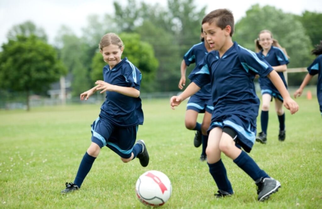 Primary school children playing football