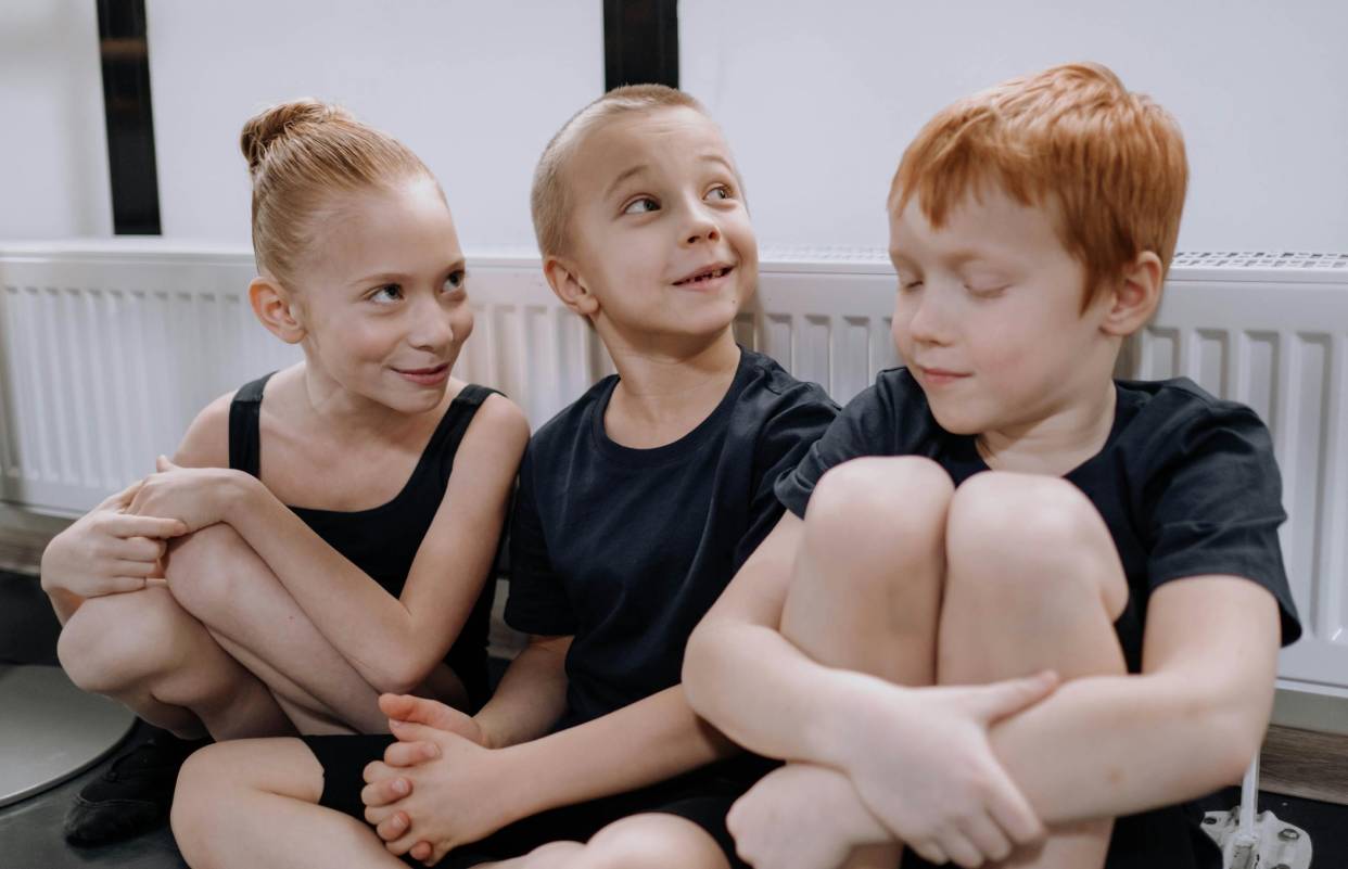 Children sit joyfully on a floor