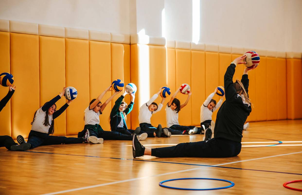 Group of children practicing volleyball stretches